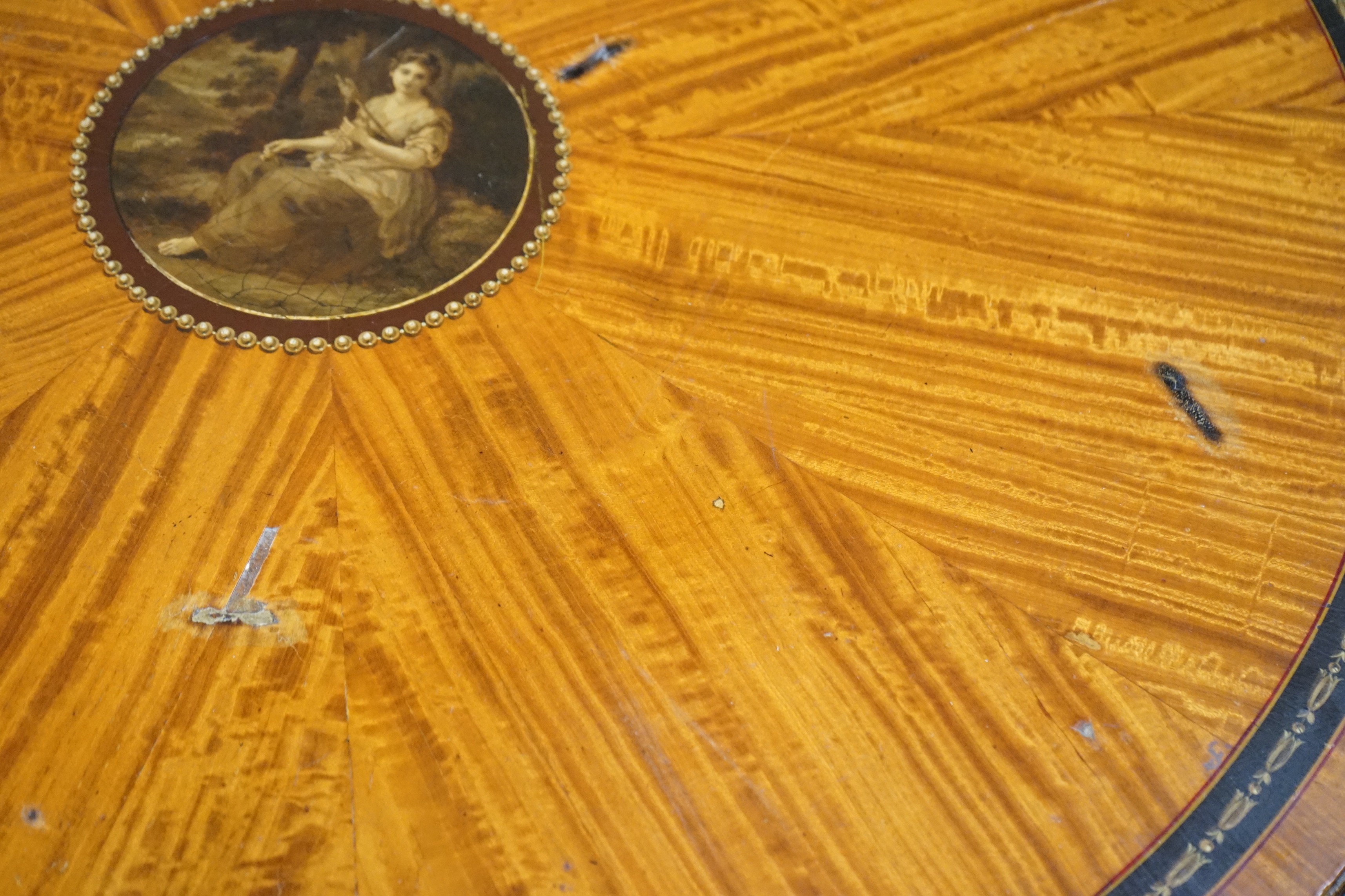An Edwardian Sheraton revival circular painted satinwood centre table, diameter 76cm, height 77cm